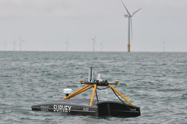 XOCEAN vehicle at sea with wind turbines in the backgroud.