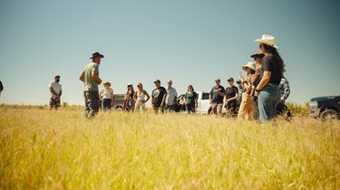 People talk in a farm field at the Regenerate AZ conference